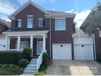 Two-story brick townhome with a well-maintained lawn and a two-car garage at 19307 Beaufain St, Cornelius, NC 28031