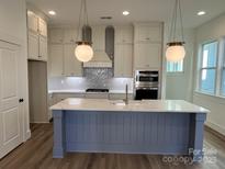 Modern kitchen with white cabinets, large island, and stainless steel appliances at 609 Hops Aly, Fort Mill, SC 29715