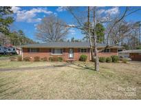 Charming brick ranch home with mature landscaping and a walkway to the front door at 1206 Mineral Springs Rd, Charlotte, NC 28262