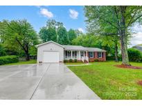 Ranch style home with brick facade, attached garage, and landscaped yard at 1308 Rama Rd, Charlotte, NC 28211