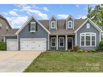 Charming home with a two-car garage, welcoming entrance, and lush green lawn at 2009 Atherton Dr, Indian Trail, NC 28079