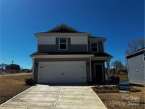 Two-story home featuring a two-car garage, neutral color scheme, and manicured landscaping at 104 Alden Ct, Shelby, NC 28152