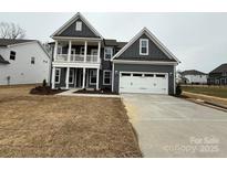 Charming two-story home with a spacious two-car garage and covered porch at 3253 Mcharney Dr # 27, Harrisburg, NC 28075