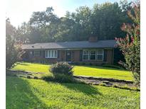 Charming brick home featuring a manicured lawn and mature landscaping at 110 Spruce Dr, Salisbury, NC 28147
