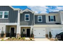 Charming townhome featuring a two-car garage and modern gray and beige siding at 1650 Village Grove Ln, Monroe, NC 28110