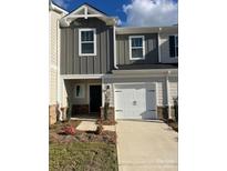 Two-story townhome featuring a one car garage and a charming front entrance at 1650 Village Grove Ln, Monroe, NC 28110