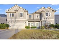 Two-story house with gray siding, white garage door, and landscaping at 9929 Markus Dr, Mint Hill, NC 28227