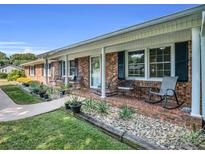Classic brick home featuring a welcoming front porch, rocking chairs, and charming curb appeal at 3039 Longwood Dr, Shelby, NC 28152