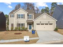 Charming two-story home with a manicured lawn, two car garage, and inviting blue front door at 225 English Arbor Dr # 13, Fort Mill, SC 29715
