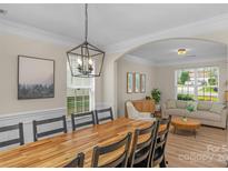 Bright dining room features a large wooden table with seating for eight at 11407 Sidney Crest Ave, Charlotte, NC 28213