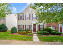 Two-story house with beige siding, brown shutters, and a landscaped lawn at 8219 Bridgegate Dr, Huntersville, NC 28078