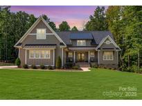 Inviting home with manicured lawn, dormer windows, and covered porch, ideal for relaxing evenings at 859 Irish Creek Dr, Landis, NC 28088