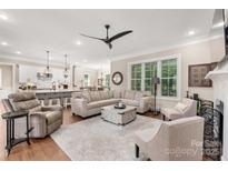 Spacious living room with hardwood floors, large sectional sofa, and open floor plan to kitchen and dining at 859 Irish Creek Dr, Landis, NC 28088