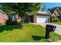 Brick ranch home with attached garage and landscaped lawn at 1273 10Th Street Pl, Hickory, NC 28601