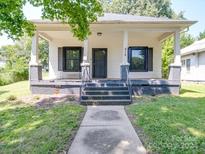 Charming white bungalow with a front porch and landscaped yard at 818 N Jackson St, Salisbury, NC 28144