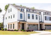Modern three-story townhome with white siding, brick accents, black trim, and a rooftop deck at 3020 Endhaven Terraces Ln # 10, Charlotte, NC 28277
