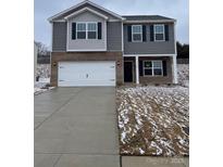 Charming two-story home showcasing a brick and gray exterior with a two-car garage at 112 Rustling Waters Dr, Mooresville, NC 28117