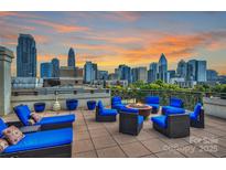 Stunning rooftop terrace with city skyline views, fire pit, and comfortable seating at 718 W Trade St # 411, Charlotte, NC 28202