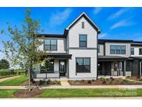 Charming two-story home featuring gray siding, black trim, a covered porch, and landscaped front yard at 97 Seven Oaks Lndg, Belmont, NC 28012