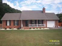 Charming brick home featuring a manicured lawn, a welcoming front porch, and a single-car garage at 3905 Autumn Wood Dr # 28, Monroe, NC 28112