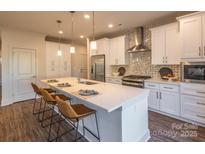 Modern kitchen with white cabinets, stainless steel appliances, and a large island at 621 Seldon Dr, Charlotte, NC 28216