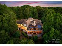 Stunning aerial view of luxury home, surrounded by lush trees and beautiful architectural design at 10310 Wildlife Rd, Charlotte, NC 28278