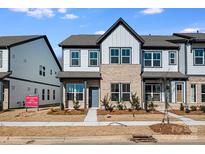 Two-story townhome with modern farmhouse exterior, landscaping, and paved walkway at 1190 Lost Cove Rd, Indian Land, SC 29707