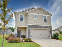 Two-story house with beige siding, stone accents, and a two-car garage at 102 Guardian Gate Dr, Mooresville, NC 28115