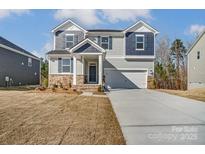 Two-story house with gray siding, stone accents, and a two-car garage at 12320 Riceland Way, Midland, NC 28107