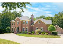 Imposing two-story brick home with a well-manicured lawn and a circular driveway leading to a side-entry garage at 5300 Green Rea Rd, Charlotte, NC 28226
