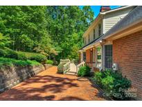 Brick patio and deck create an inviting outdoor space, nestled beside lush landscaping at 118 Cramer Mountain Woods Rd, Cramerton, NC 28032