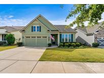 Charming home features a 2-car garage, manicured lawn, and lush landscaping at 8121 Festival Way, Charlotte, NC 28215