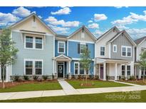 Three-unit townhome building, featuring light blue, gray, and white exteriors at 10507 Boudreaux St, Huntersville, NC 28078