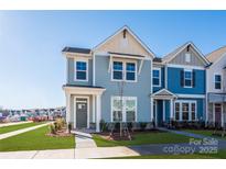 Two-story townhome with light blue siding, and a grassy front yard at 10505 Boudreaux St, Huntersville, NC 28078