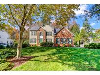 Charming two-story home with a manicured lawn, brick and vinyl siding, and complemented by lush, mature trees at 138 Huntly Ln, Mooresville, NC 28115