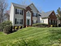 Traditional two-story home featuring a brick facade, lush lawn, and manicured shrubbery at 138 Huntly Ln, Mooresville, NC 28115