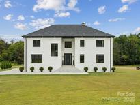 Stunning two-story white brick home with black trim and a large front yard at 2109 Goose Creek Farm Ln, Indian Trail, NC 28079