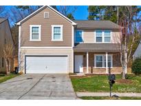 Two-story house with neutral siding, stone accents, and a two-car garage at 3308 Lemongrass Ln, Charlotte, NC 28214