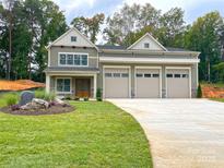 Two-story home with a three car garage, stone accents, and manicured lawn at 139 Poplar Grove Rd, Mooresville, NC 28117