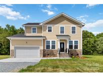 Charming two-story home with stone accents, a well-manicured lawn, and an attached two-car garage at 1034 Heath Helms Rd, Monroe, NC 28110