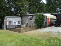 Charming home exterior with a fenced yard and shed, creating a cozy and functional outdoor space at 112 S Cardinal Dr, New London, NC 28127