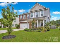 Two-story brick home with attached garage and landscaped front yard at 129 Eden Ave, Mooresville, NC 28115