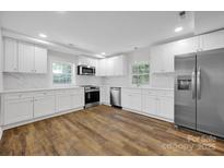 Modern kitchen featuring white cabinets, stainless steel appliances, and quartz countertops at 123 Market Rd, Mooresville, NC 28115