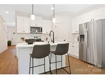 Modern kitchen with white cabinets, stainless steel appliances, and an island at 734 Cantwell St, Charlotte, NC 28208