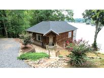 Charming cedar home with stone pathway, mature landscaping, and serene lake views at 152 Bridge Pointe Ln, Hickory, NC 28601