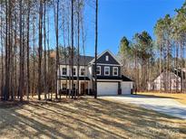 Beautiful two-story home boasts a three-car garage and is surrounded by a lush, wooded landscape at 1021 Baylor Grv, Monroe, NC 28110