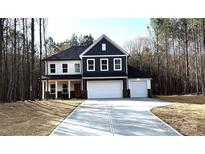 Two-story home featuring a dark-blue and white exterior, a two-car garage, and a long concrete driveway at 1021 Baylor Grv, Monroe, NC 28110