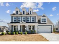Charming two-story home with a blue exterior, well-manicured landscaping, and a two-car garage at 2140 Indigo Branch Rd, Indian Land, SC 29707