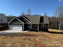 New construction home features a covered front porch, two-car garage and a professionally landscaped front yard at 59 Browning Dr, Taylorsville, NC 28681