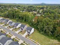 An aerial view shows a neighborhood with lush green trees and well-maintained homes at 3414 Laurel Oak Ln, Gastonia, NC 28056